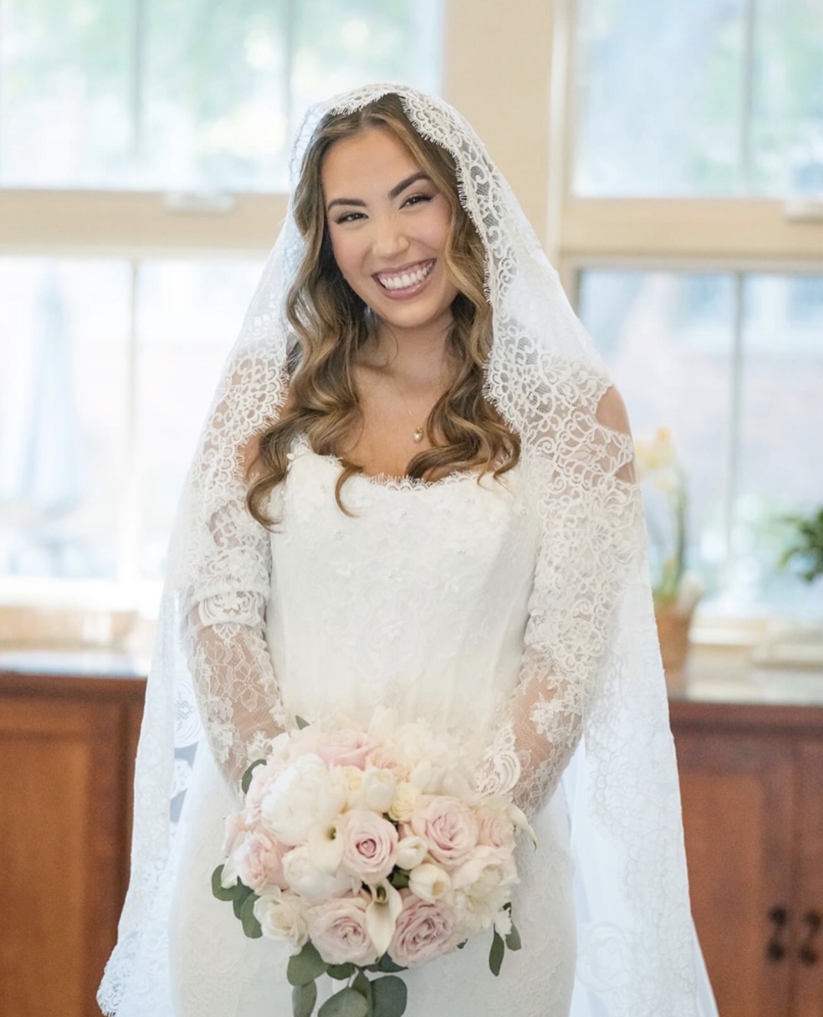 Bride in lace veil with luminous natural bridal makeup