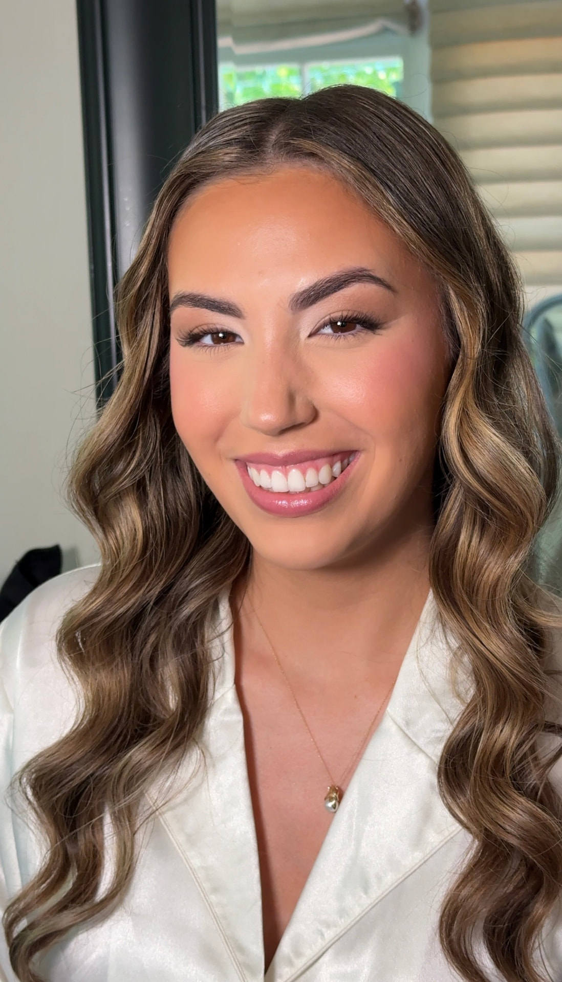 Polished bridal makeup with soft shimmer and rosy cheeks